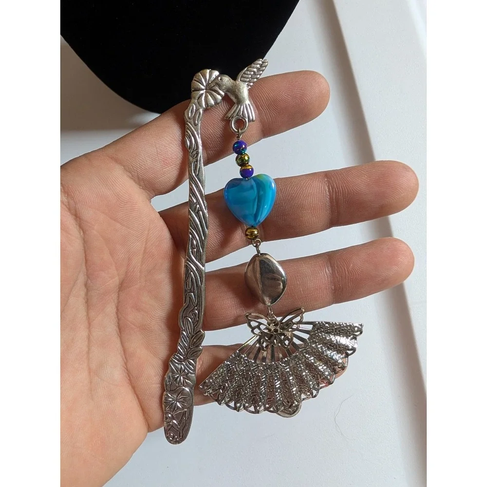 metal hook bookmark with a beaded charm featuring a fan pendant and a blue heart